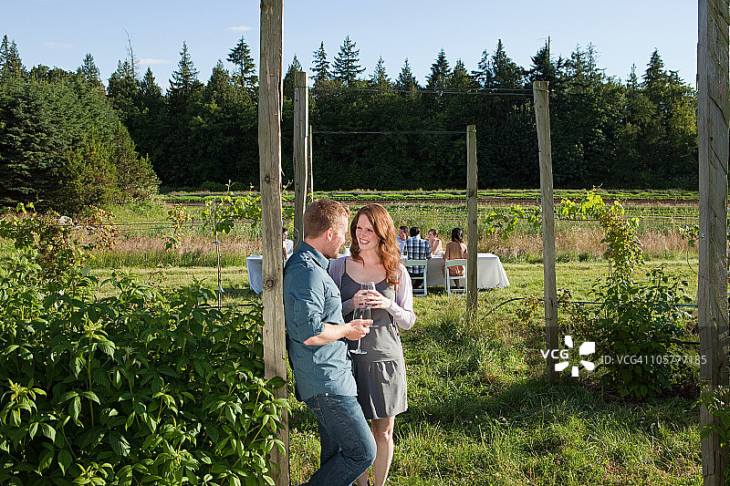 一对年轻夫妇在农场上，戴着酒杯图片素材