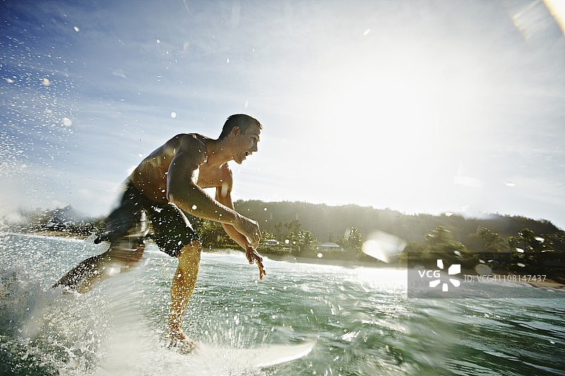 一名男性冲浪者在水中冲浪图片素材