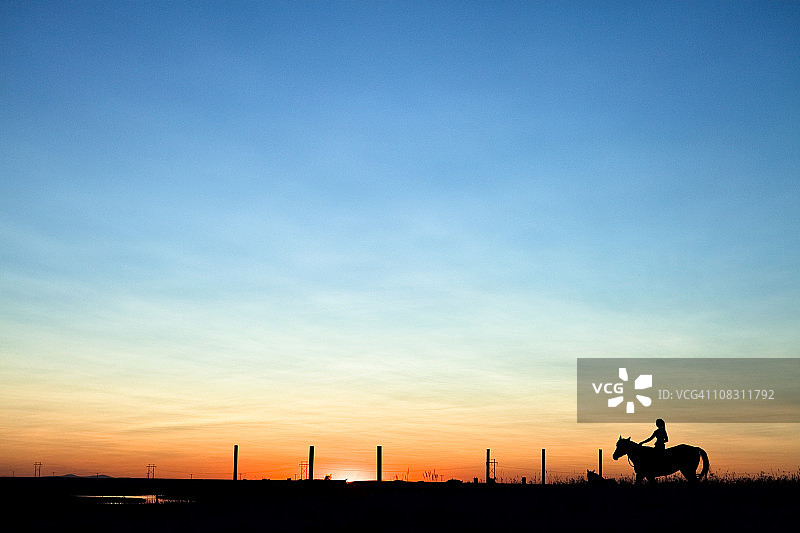 马和女人在夕阳中图片素材