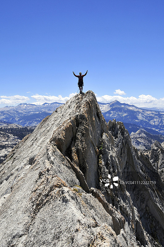 加州约塞米蒂国家公园，一名攀岩者伸开双臂站在Matthes Crest上。图片素材