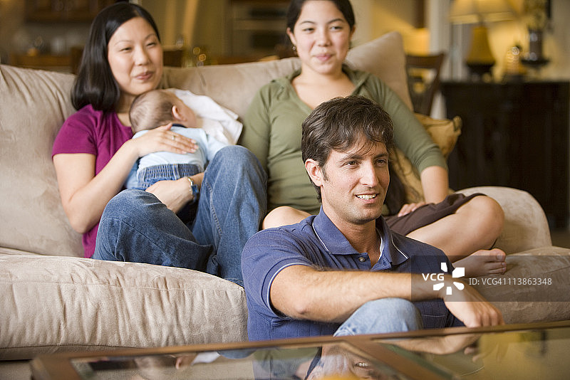 一个家庭坐在沙发和地板上的肖像图片素材