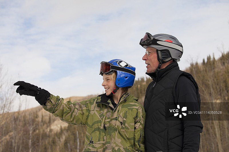 一对戴着滑雪面罩和头盔的父子在滑雪场图片素材
