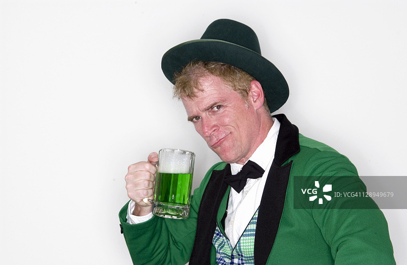 一个穿得像小妖精的男人，手里拿着一大杯绿啤酒图片素材