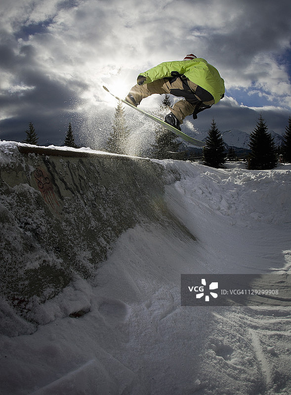 单板滑雪运动员在u型场地上跳跃图片素材