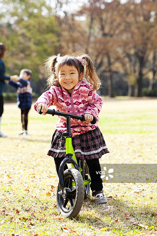 小女孩骑着平衡脚踏车。图片素材