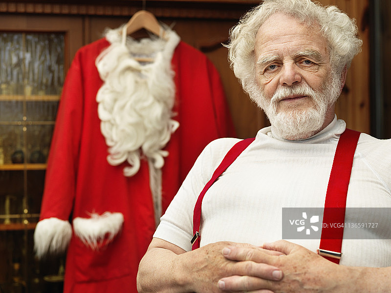 男人穿着圣诞老人的衣服坐着图片素材