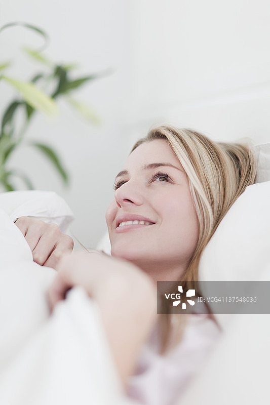 微笑的女人躺在床上图片素材