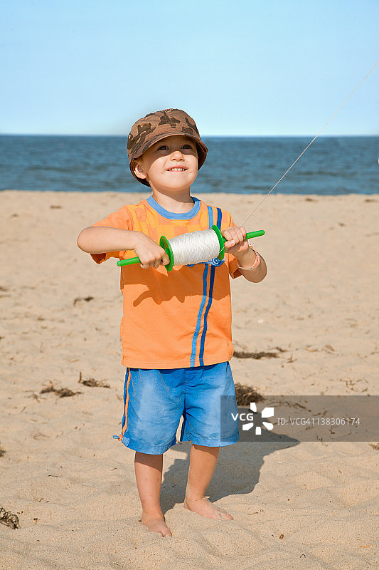 男孩(2-3岁)在海滩上放风筝图片素材
