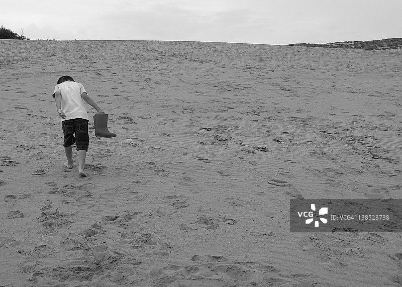 一个小男孩在爬鸟取沙丘图片素材