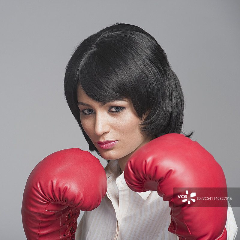 一个戴拳击手套的女商人的肖像图片素材