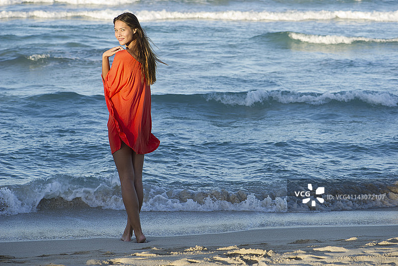 年轻女子站在海滩上图片素材