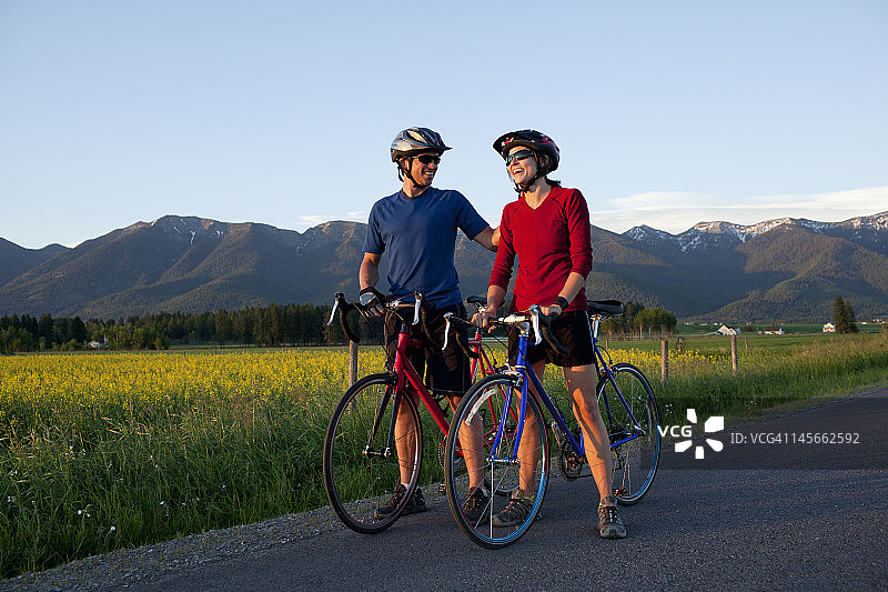 骑自行车的情侣一边欣赏风景一边大笑图片素材
