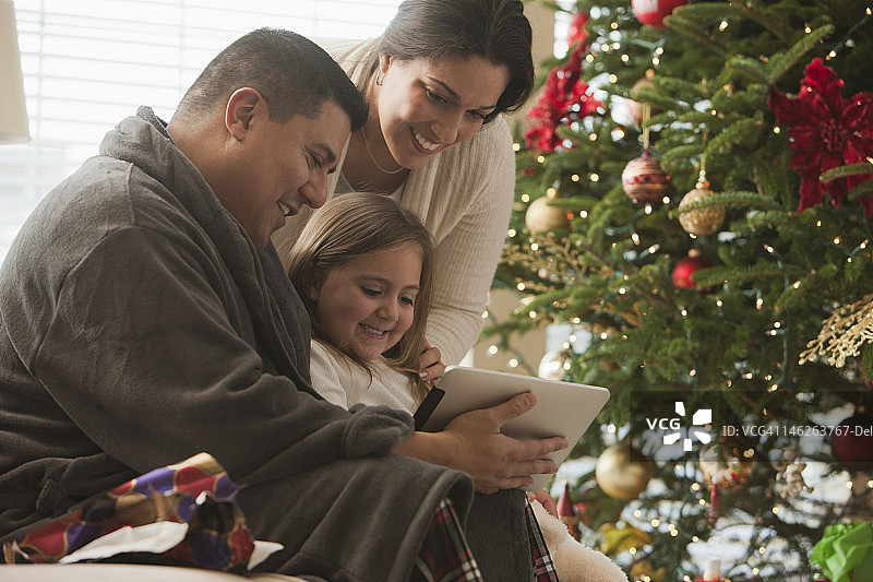 圣诞节早上一家人在看数字平板电脑图片素材