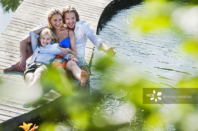 奥地利萨尔茨堡县，一家人坐在天然泳池上的桥上图片素材