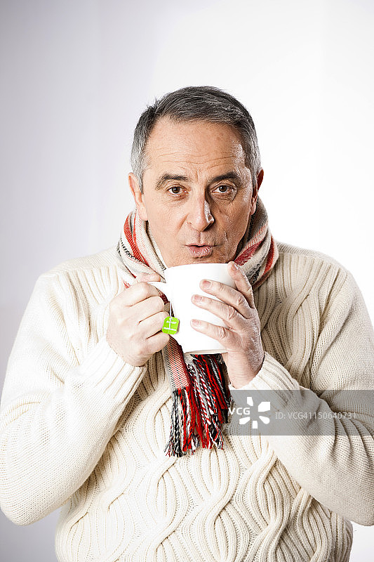 老人穿着冬衣喝着茶图片素材