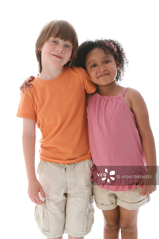 男孩(8-9)和女孩(6-7)站在一起，彼此靠在一起图片素材