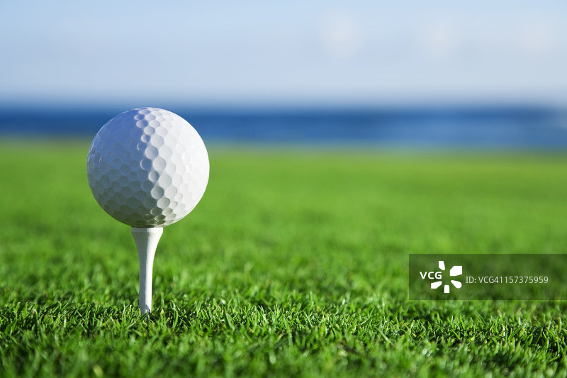 高尔夫球在球座与海景图片素材