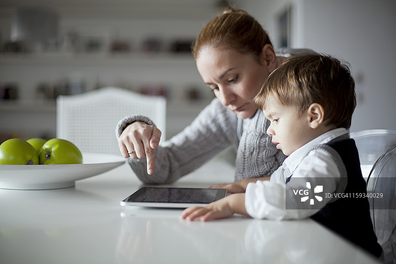 小男孩和妈妈在看平板电脑图片素材