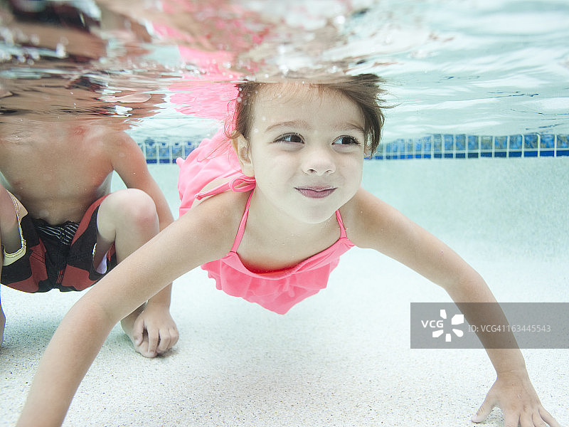 美国，犹他州，奥勒姆，男孩(4-5)和女孩(4-5)在游泳池游泳图片素材