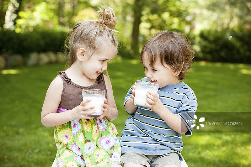 两个小孩在户外喝牛奶图片素材