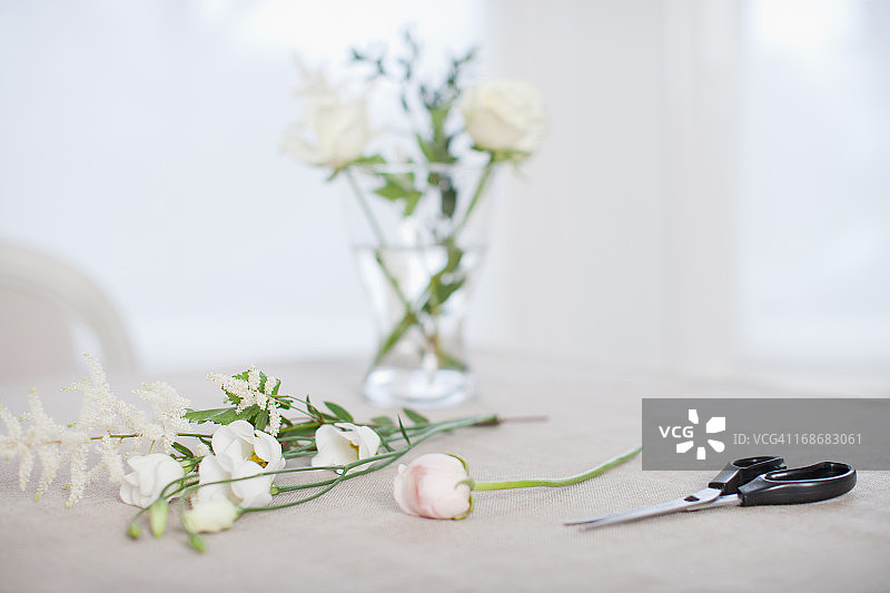 桌上放着鲜花和花瓶，还有剪刀图片素材