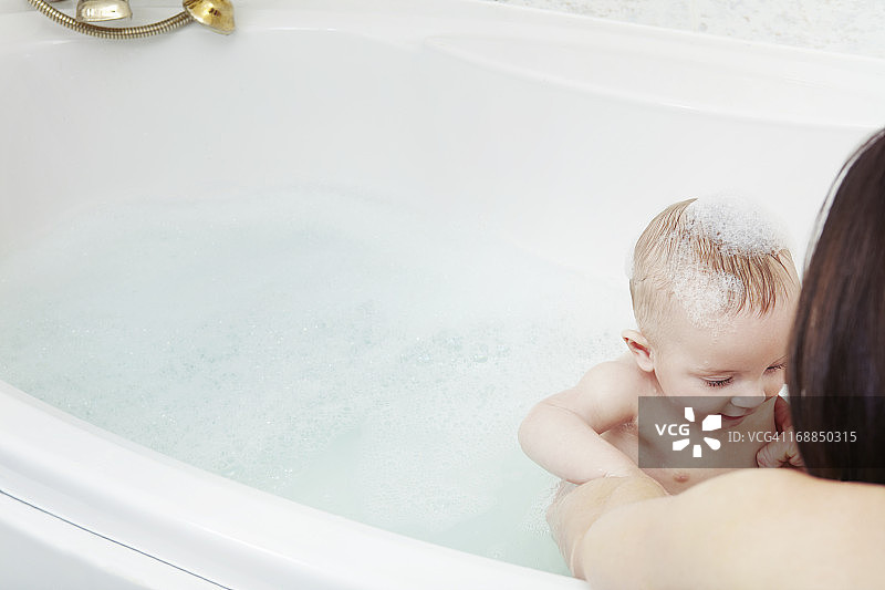 母亲在泡泡浴中给女婴洗澡图片素材