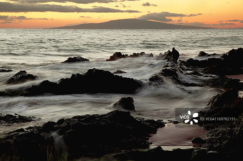 日落时海浪冲刷着熔岩图片素材