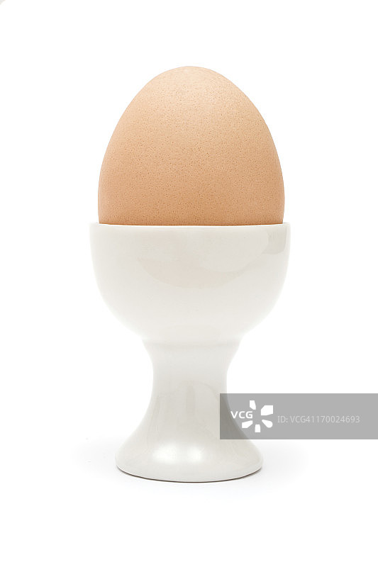 棕色鸡蛋放在白色蛋杯里图片素材