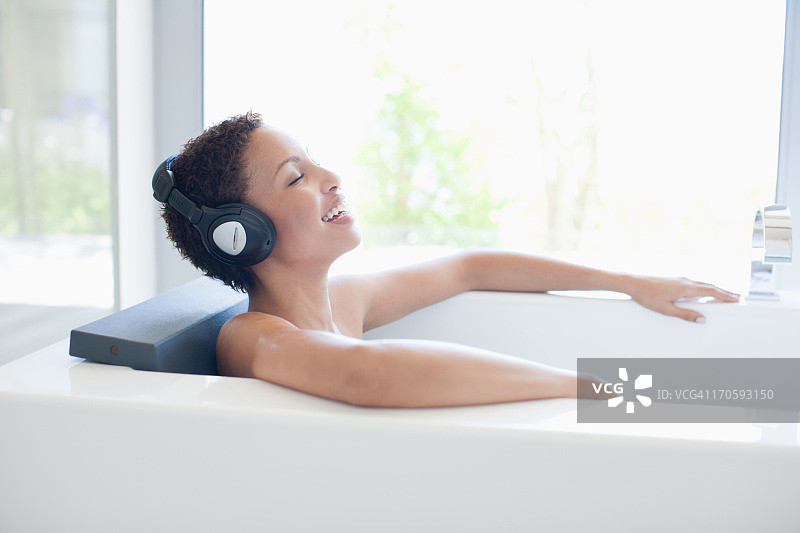 在浴缸里听音乐的女人图片素材