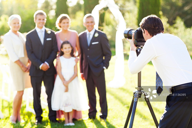 一名男子在户外婚礼上拍摄家庭照片图片素材