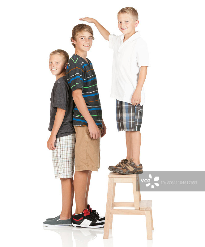 小男孩站在凳子上比较身高图片素材