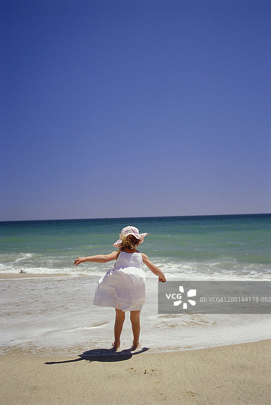 女孩(4-6)在海滩看海，后视图图片素材