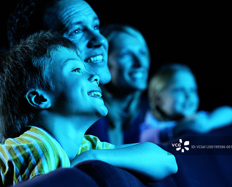 家长和孩子(8-10)在电影院，微笑(关注男孩)图片素材