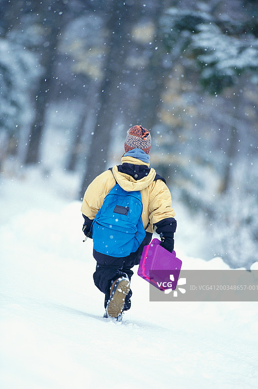 女孩(6-8)在雪地里步行上学，后视镜图片素材