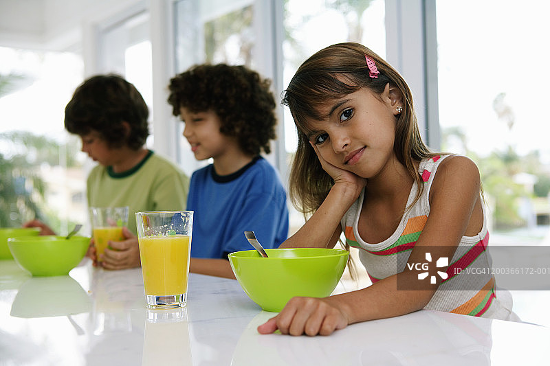 三个孩子(8-10岁)在餐桌上，吃早饭，画像图片素材