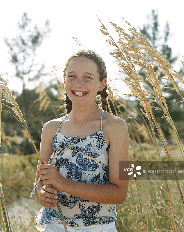 女孩(11-13)在海滩微笑，肖像，特写图片素材