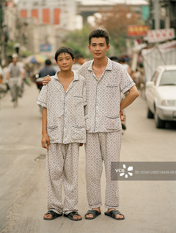少年(14-16岁)和成年兄弟穿着睡衣，肖像图片素材