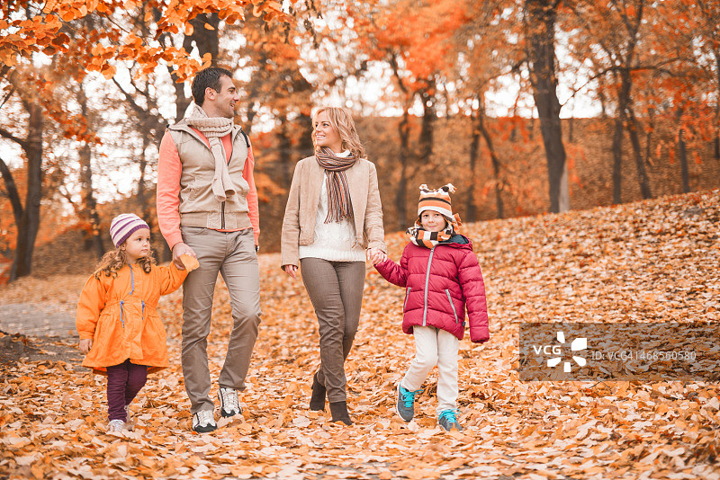 一家人在大自然中散步，享受秋天的快乐。图片素材