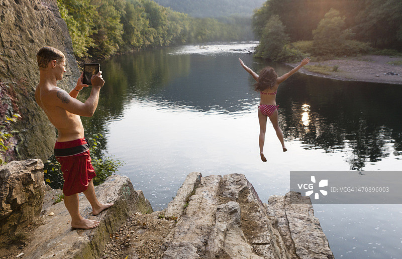 年轻夫妇拍摄从岩石上跳下来，汉堡，宾夕法尼亚州，美国图片素材