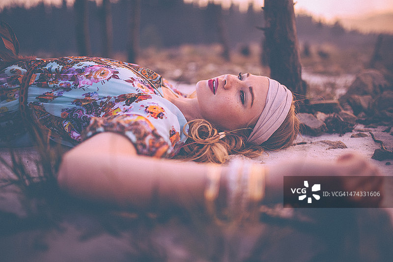 波西米亚女孩躺在地上，穿着复古的花裙子图片素材
