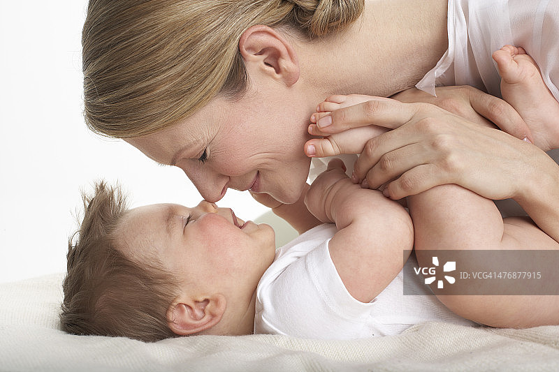 母亲和她的男婴鼻子对鼻子接吻图片素材