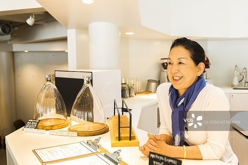 年长日本妇女在咖啡馆服务图片素材