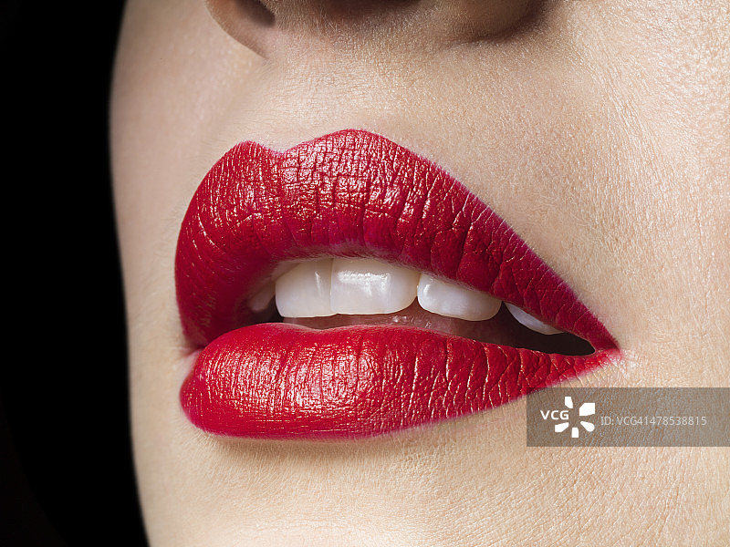 女性的嘴唇涂上红色的口红，完美的牙齿图片素材