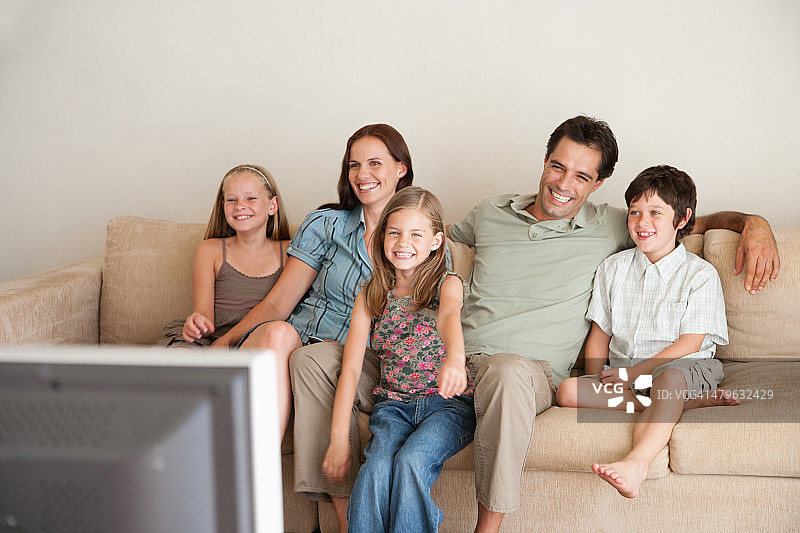 一个年轻的家庭在看电视图片素材