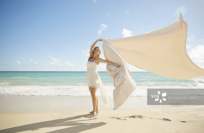 一个白人女人在沙滩上玩毯子图片素材