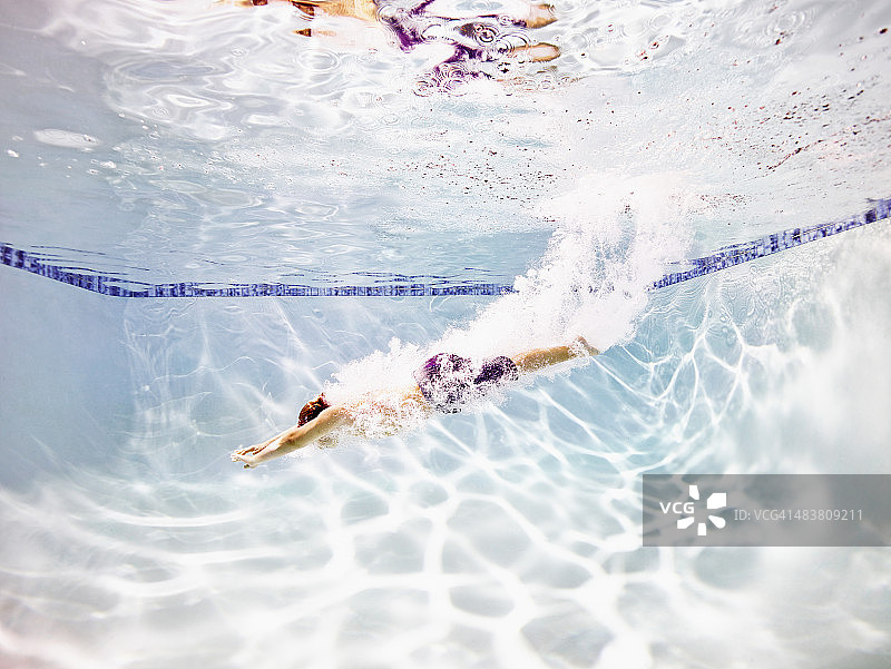 年轻的男子游泳运动员跳入游泳池图片素材