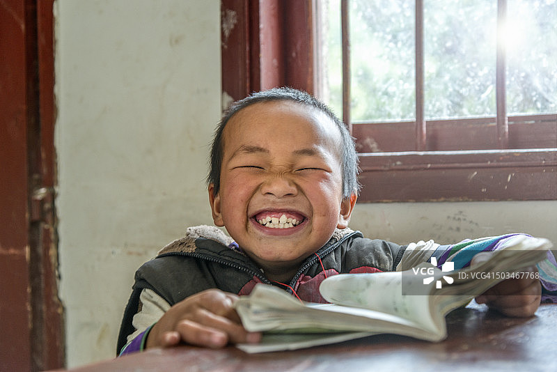 中国男孩笑容满面地在学校，看着镜头图片素材