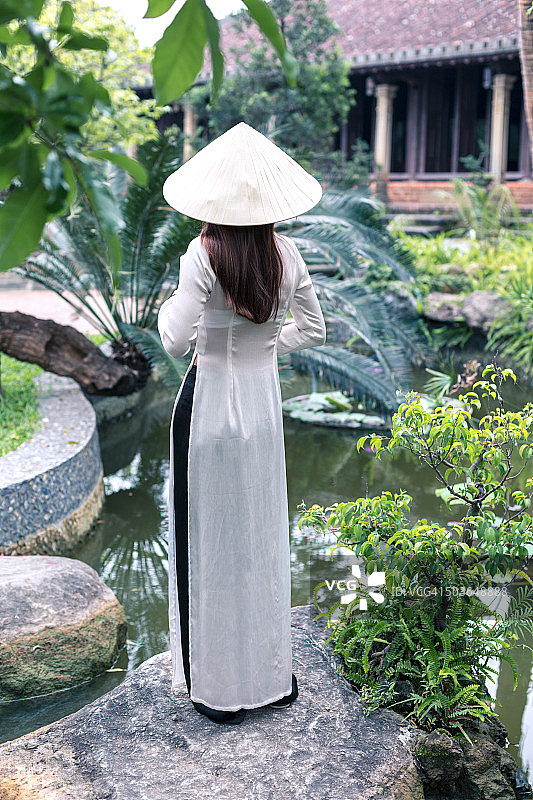 年轻的越南女孩在一个典型的亚洲花园图片素材