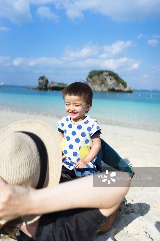 母亲和一个小女孩在热带海滩上玩，冲绳，日本图片素材