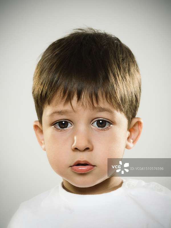 一个焦虑的孩子看着相机的肖像。图片素材